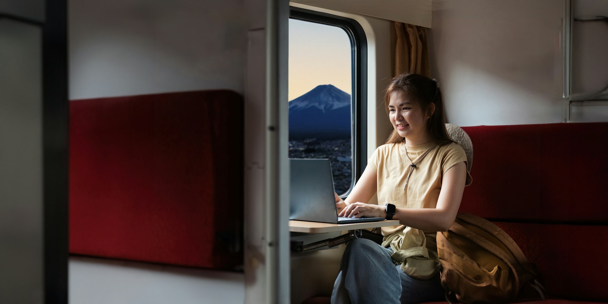 Traveler young woman travel in train. Remotely work on laptop during sitting inside . travelling